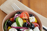 fresh greek salad in clay bowl