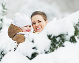Portrait of smiling mother and baby in winter park