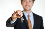 Smiling businessman handing keys 