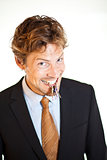 Smiling businessman holding keys between his teeth