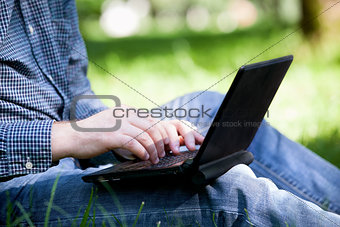 Detail of hands and laptop keyboard.
