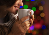 Closeup on smiling young woman with cup of hot chocolate with ma