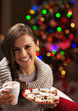 Portrait of smiling young woman with cup of hot beverage and chr