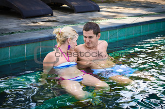 Happy smiling couple in swimming pool