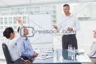 Businesswoman asking question during her colleagues presentation