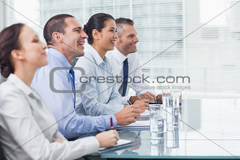 Coworkers smiling while listening to presentation