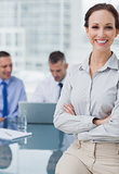Cheerful businesswoman posing leaning against the desk