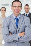Serious entrepreneur posing with his colleagues on background