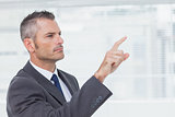 Pensive businessman pointing out while looking away