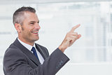 Cheerful businessman pointing while looking away
