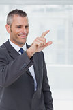 Cheerful businessman pointing and looking straight ahead