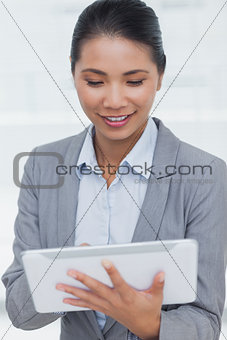 Happy businesswoman posing scrolling on her tablet pc