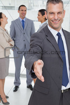 Cheerful businessman introducing himself holding out his hand