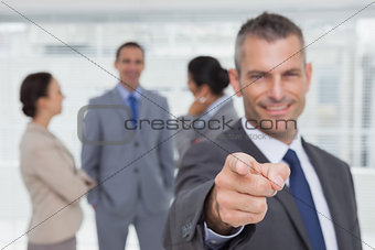 Cheerful businessman pointing at camera