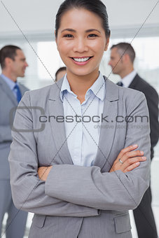 Businesswoman posing while colleagues talking together
