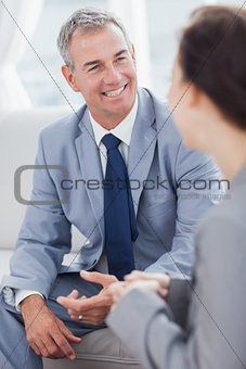 Smiling businessman talking to his workmate