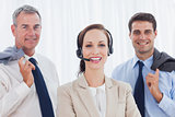 Cheerful call center agent posing with her work team