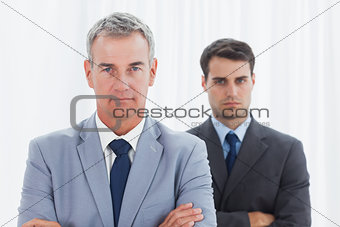 Stern businessmen posing crossing arms