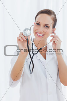 Happy nurse posing holding her stethoscope