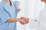 Close up on surgeon and doctor shaking hands