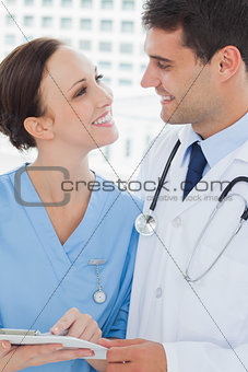 Smiling doctor and surgeon attractively looking at each other