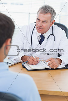Serious doctor prescribing drug to his patient