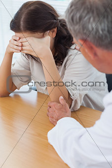 Upset patient crying while doctor comforting her
