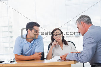 Serious couple negociating with real estate agent