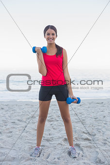 Sporty woman exercising with dumbbells