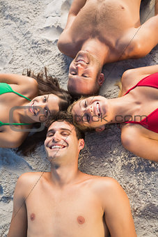 Overhead of smiling friends lying together in a circle