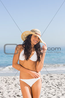 Smiling attractive young woman wearing straw hat posing