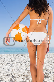 Back of womans perfect body holding beach ball