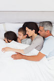 Beautiful family sleeping together in bed