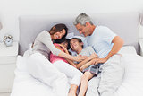 Happy family lying on bed