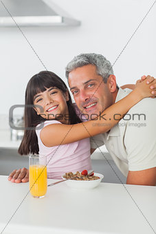 Cheerful little girl giving a hug to her father