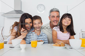 Beautiful family eating breakfast in kitchen together