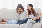 Mother sitting with her children on sofa