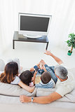 Family with popcorn watching their television on sofa