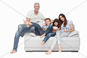 Family sitting on sofa smiling at camera