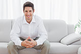 Happy young man sitting on sofa
