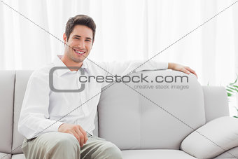 Stylish young man sitting on sofa