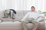 Tired businessman sitting back on sofa