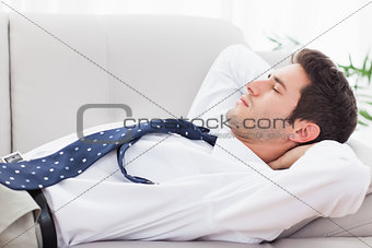 Businessman lying on sofa sleeping