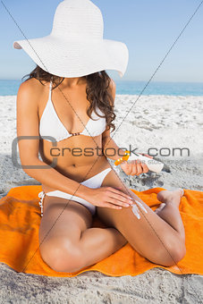 Close up of young woman applying sun cream