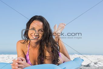 Happy attractive brunette lying on her lilo