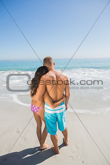 Loving couple hugging while looking at the sea