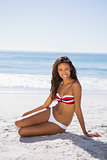 Attractive young tanned woman in bikini posing