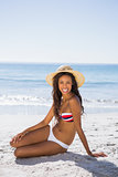 Attractive young tanned woman wearing straw hat posing