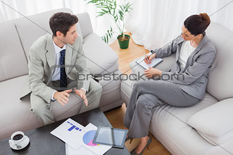 Businessman talking while colleague is taking notes