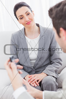 Smiling coworkers talking sitting on sofa